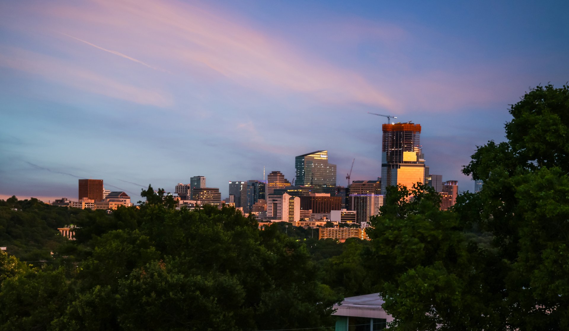 Austin, Texas skyline at dusk viewed through the trees
