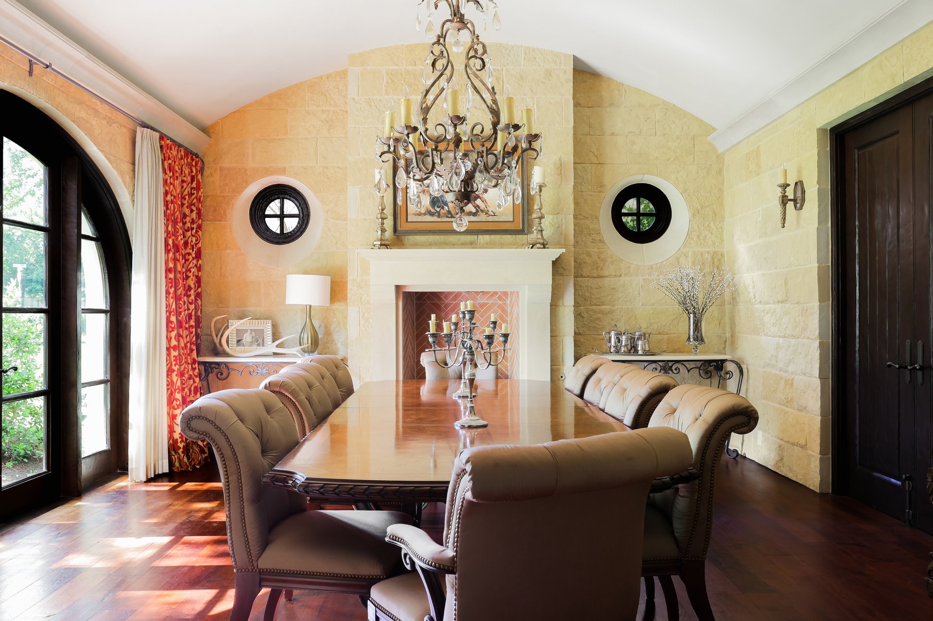 Formal dining room with stone walls, vaulted ceiling, and crystal chandelier
