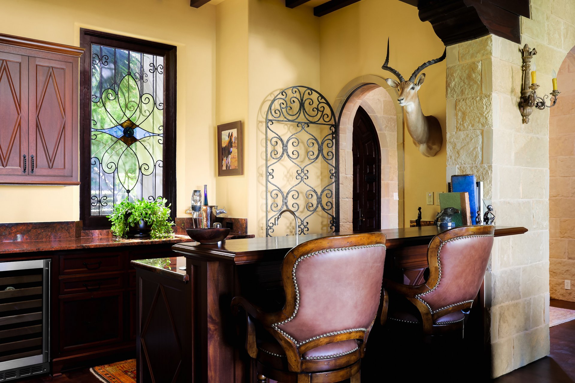 Bar with stained-glass window, stone column, and arched doorway