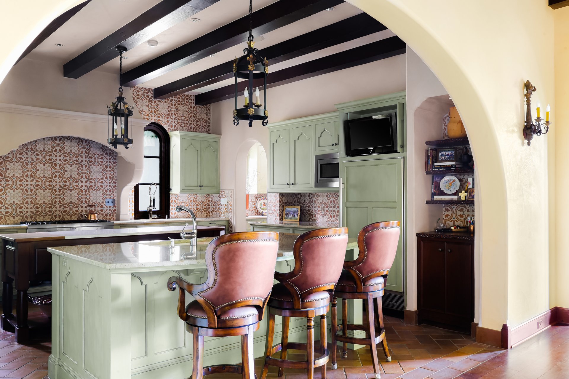 Kitchen with sage cabinetry, patterned tile, and beamed ceiling